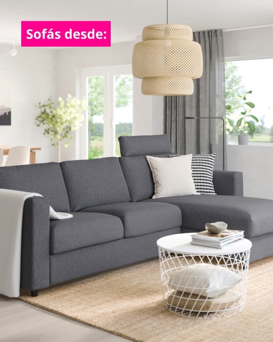 Sofá gris oscuro en una salita con alfombra beige.