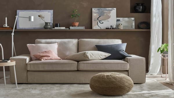 Sofa KIVIK beige con cojines rosados y azules.