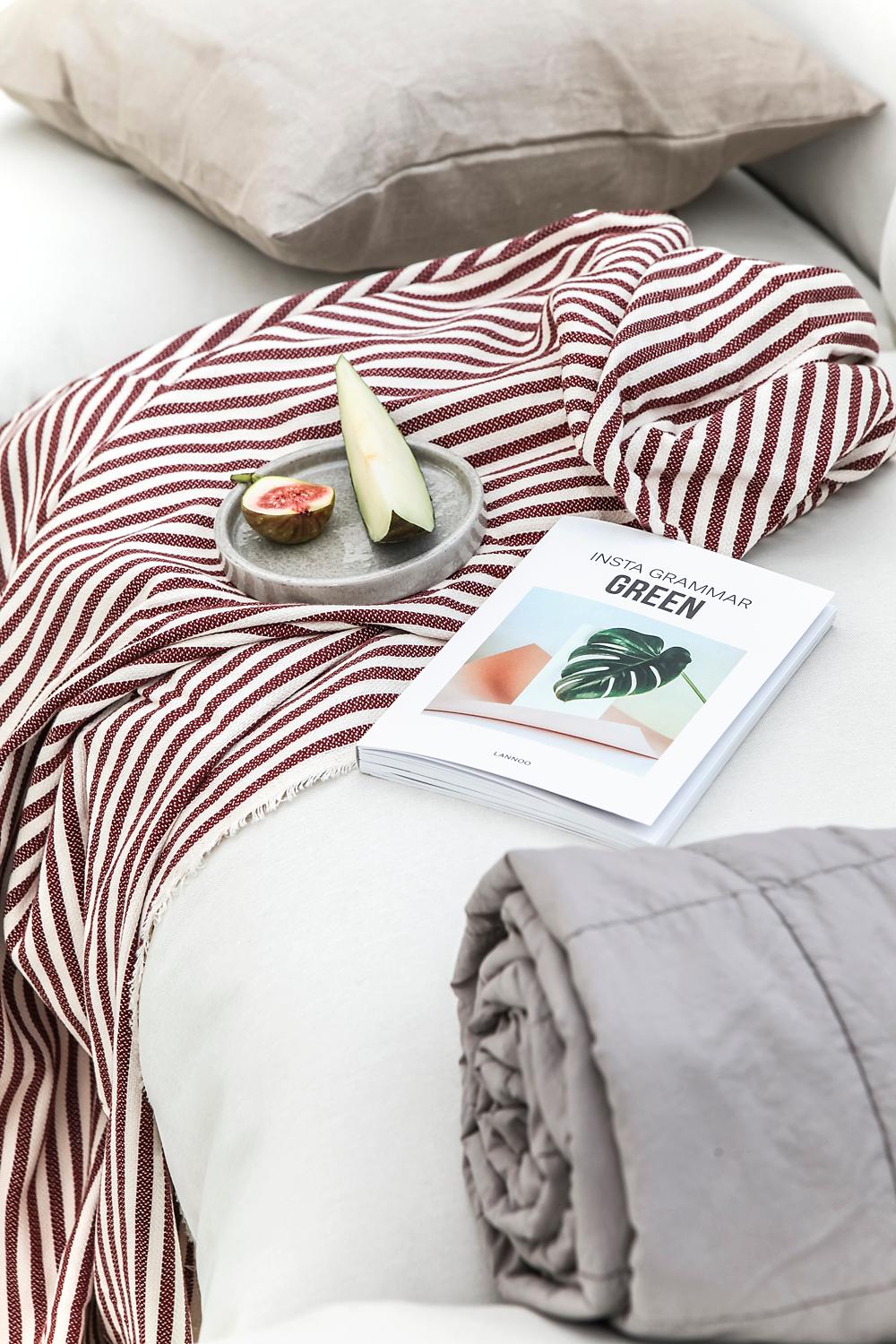 Sofa med AINA putetrekk og ett pledd. 