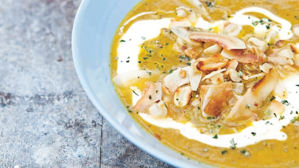 Sopa de cenoura com cobertura de coco e amendoim e iogurte