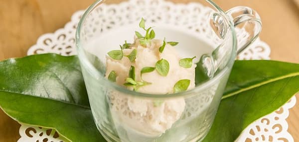 Sorbetto di tè al pino in un bicchiere di vetro trasparente.