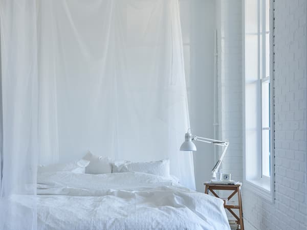 Spálňa rozdelená závesom.