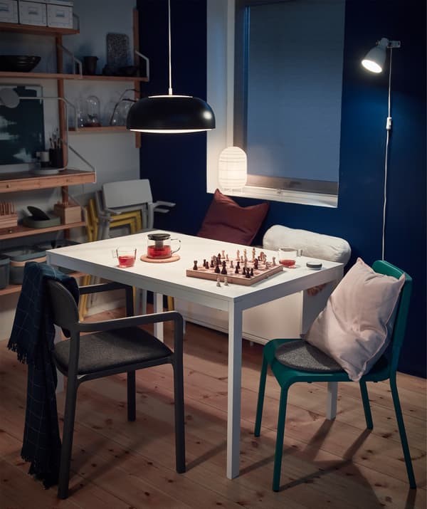 Spend cosy nights around the table. Bring out soft IKEA GURLI cushions and VÅRKRAGE polyester blankets from a white MACKAPÄR storage bench. It has sliding doors for storage. Adjustable and flexible lighting like HEKTAR puts focus on the table.