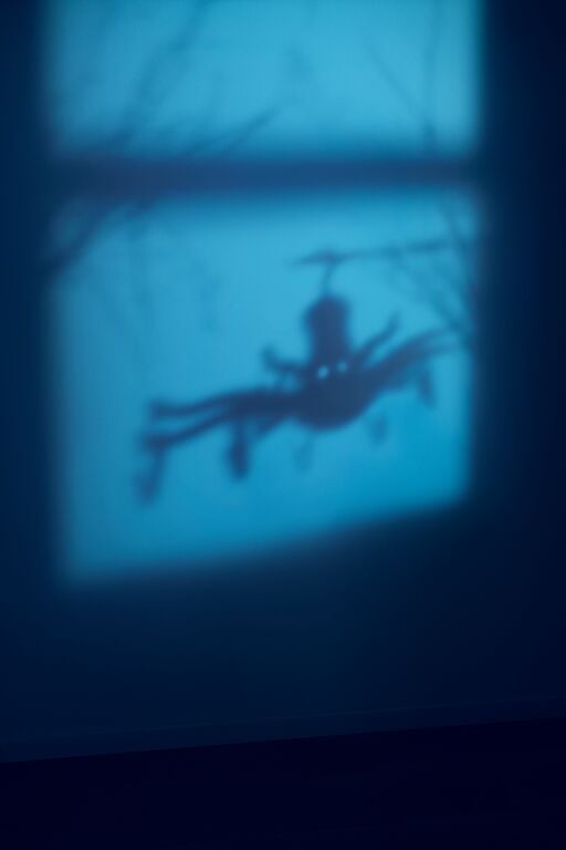 Spooky image of a clothespin holder’s shadow cast on the wall.