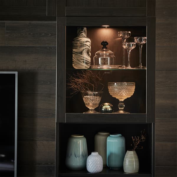 Spot à LED VAXMYRA en finition aluminium, installé dans une vitrine et mettant en valeur de beaux vases et verres.