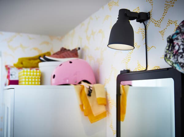 Spotul cu clemă HEKTAR de la IKEA este o veioză reglabilă cu o culoare gri modernă.  Ridică abajurul sau coboară-l, pentru a direcționa sursa de lumină. 