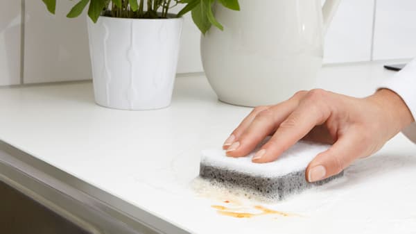 Spülbecken und Arbeitsplatten reinigen für Küchenhygiene.