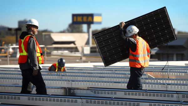 ソーラーパネルを屋根の上で組み立てている作業員