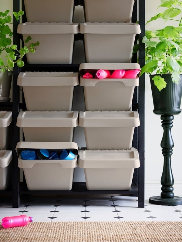 Stackable SORTERA waste sorting bins arranged vertically against a wall, perfect for recycling in a compact space.