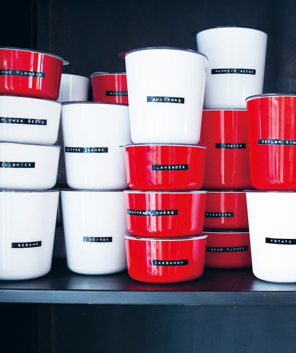 Stacks of red and white pots labelled with dry ingredients.
