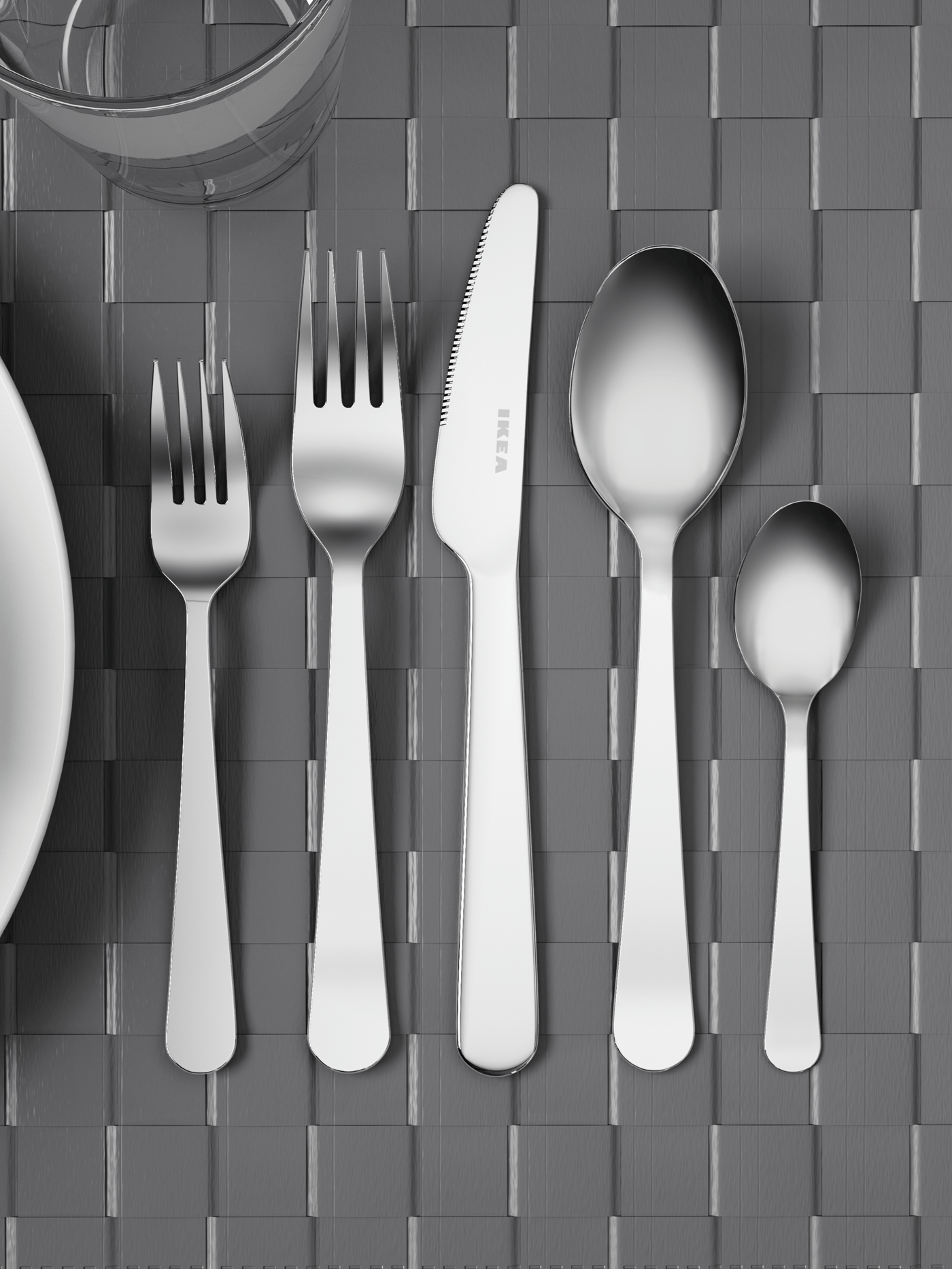 Stainless steel cutlery set including knife, fork, spoon, and teaspoon arranged on textured placemat – Cutlery from ₹99