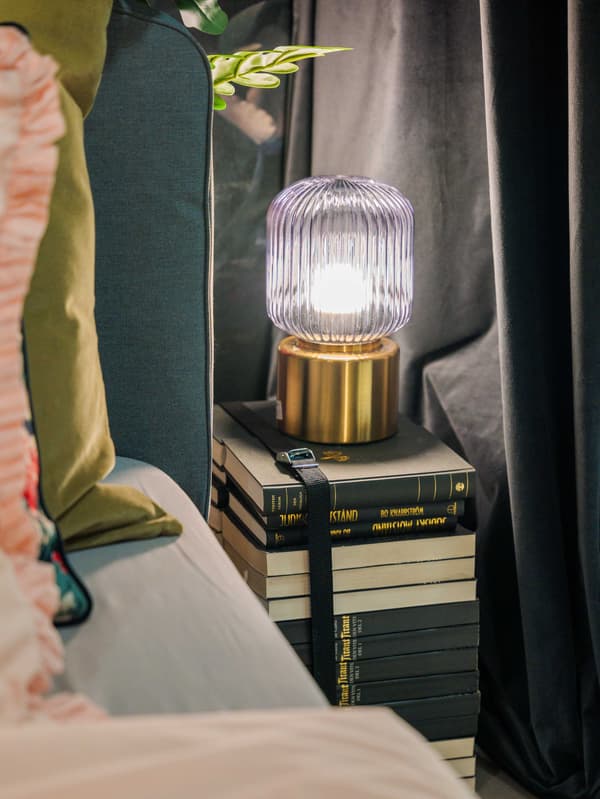 Staré knihy mohou sloužíci jako noční stolek, na kterém ja lampa.