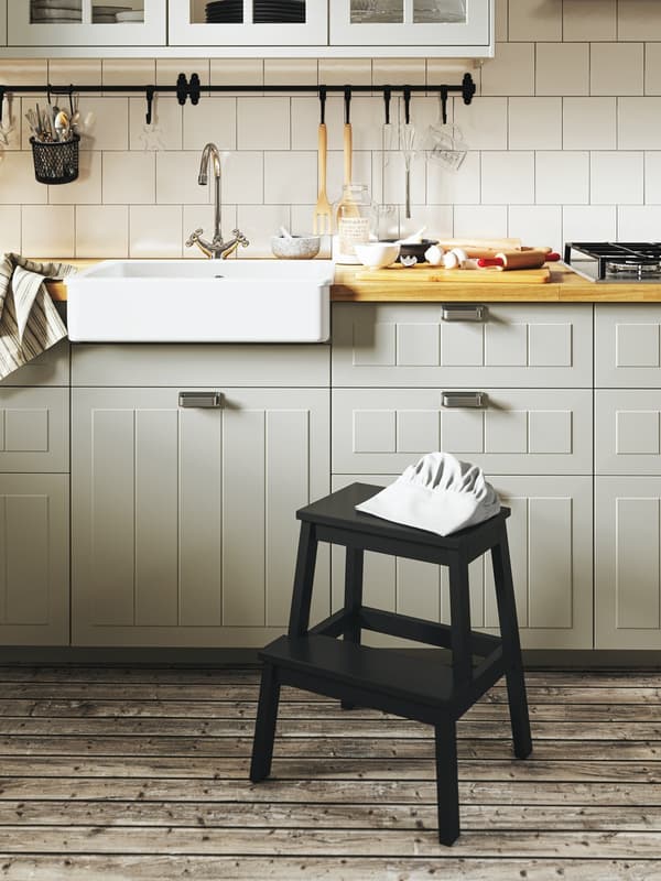 STENSUND beige kitchen with a black step stool in front and a wood worktop