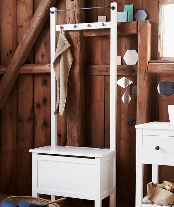 Štíhla biela úložná lavica IKEA HEMNES s vešiakom na uteráky a úložným priestorom je vhodná do malých priestorov.