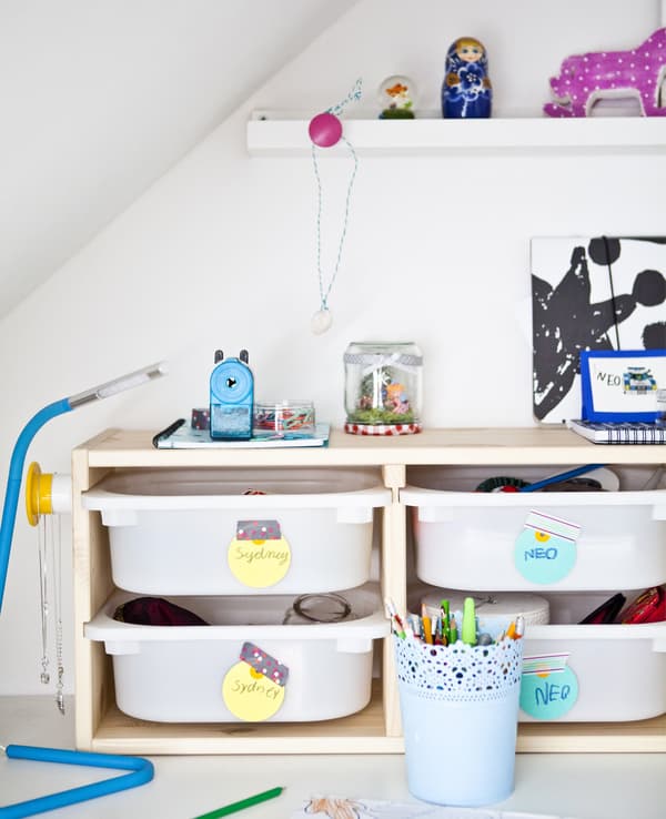Storage bins with colourful labels in a TROFAST frame add toy storage to this children's bedroom.