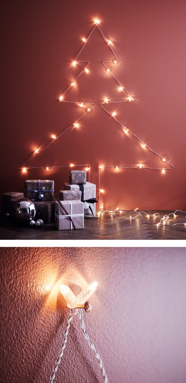 String lights arranged on a wall in a Christmas tree shape.
