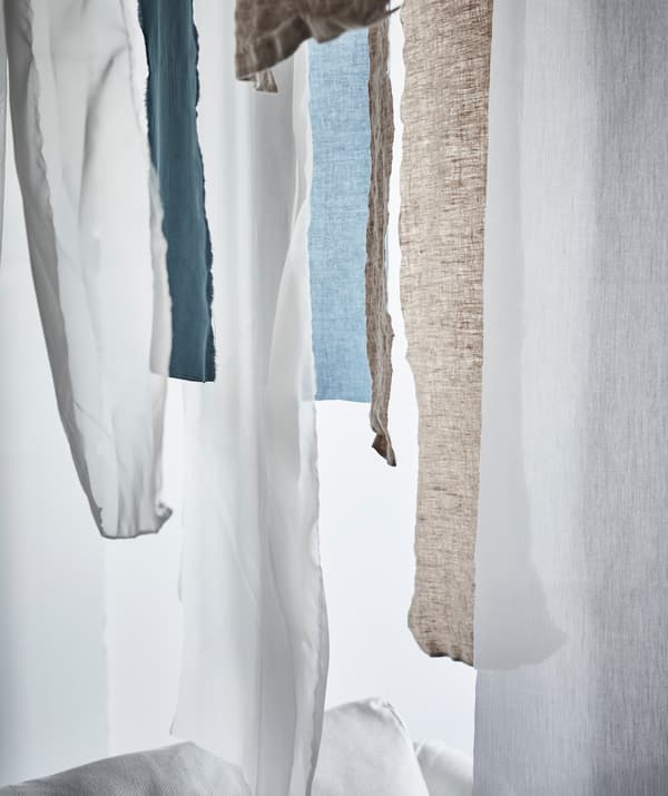 Strips of hanging textile fabric in front of a window.