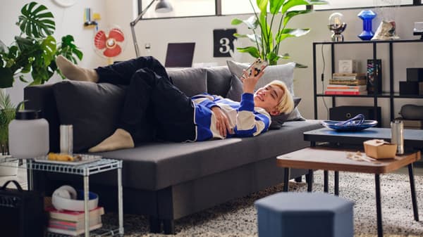 Student laying on a couch looking at his phone