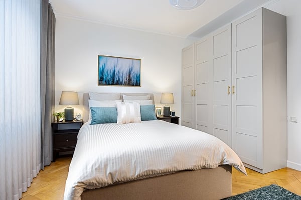 Stylish bedroom with double bed, white wardrobe, and decorative artwork