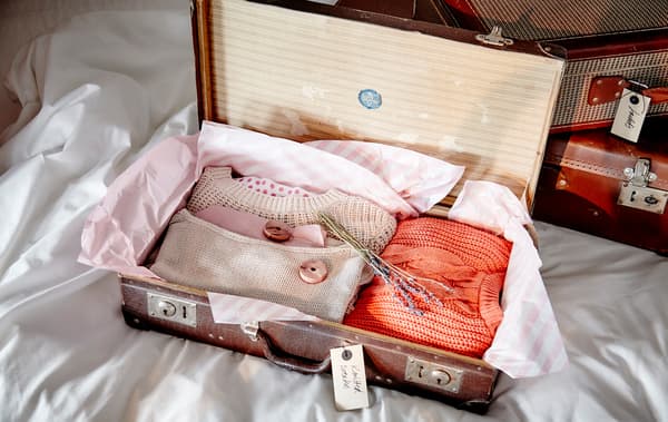 Suitcases make great storage space. They’re made for carrying clothes and often take up a bit of room themselves, so using them as storage makes them doublty useful. Add some acid-free tissue paper lining if your bags are a little older and use some lavender or cedar blocks to keep away any bugs.