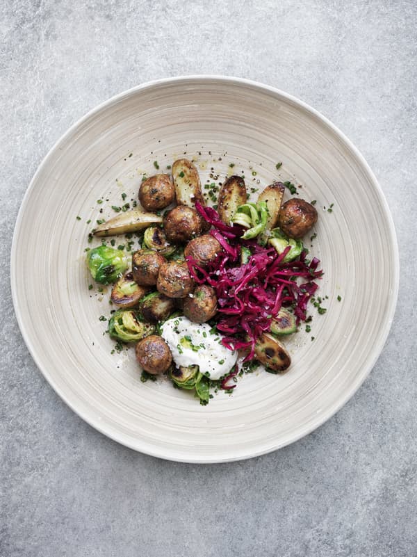 Summer salad with veggie balls served on a wooden plate, seen from above.