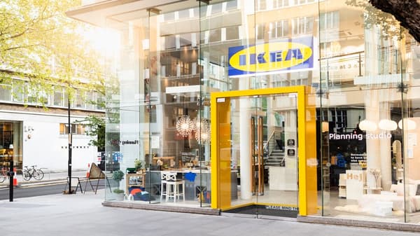 Sunce sija kroz stakleni izlog IKEA robne kuće u centru grada. Ulaz je uokviren jarkožutom bojom.