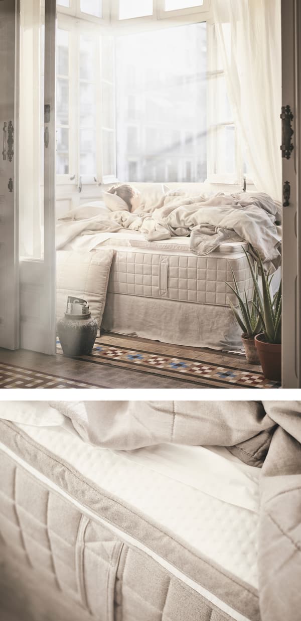 Sunlight shining on a bed with natural-coloured bedding.