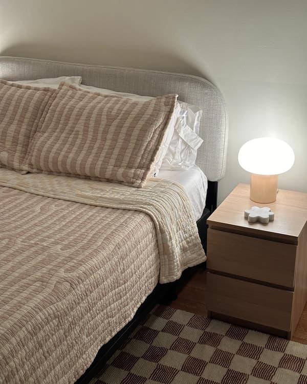 Suomalaisen Hanna-Kaarina Heikkilän suunnittelema DEJSA-pöytävalaisin vaaleassa makuuhuoneessa.