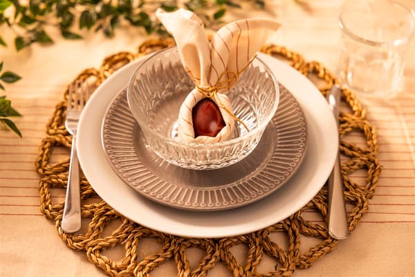 Sur une assiette, une serviette sert de décoration et, à l'intérieur, se trouve un œuf rouge.