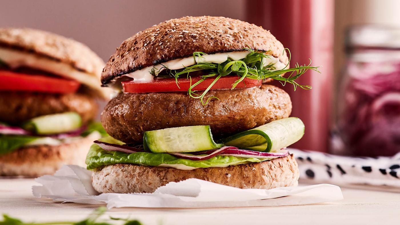 Sušenky s čokoládou na mřížce LÄTTBAKAD, vedle stojí odměrka VARDAGEN s mlékem a miska se solí.