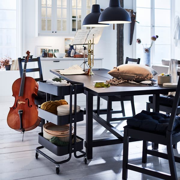 Svart NORDVIKEN utdragbart bord har här dragits ut för att skapa extra bordsyta för pyssel, musik och hobbyer.