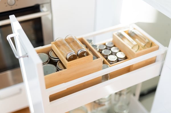 Светлая обеденная зона в скандинавском стиле с белым столом, синими стульями и современной кухней на заднем плане
