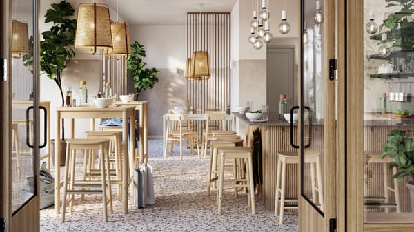 Svetli, prozračni restoran s uredno raspoređenim RÖNNINGE barskim stolovima i barskim stolicama od brezovine ispod KNIXHULT visilica od bambusa.
