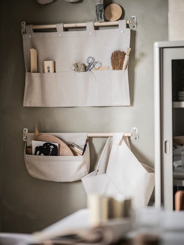 Svetlobéžová stena, na nej sú umiestnené dva závesné úložné diely NEREBY prírodnej farby.