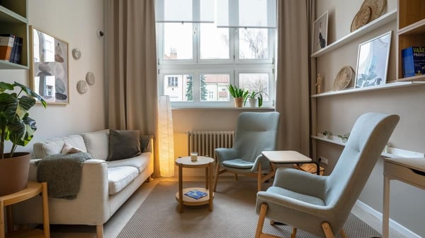 Světlý a prostorný obývací pokoj s pohodlnou pohovkou, dvěma křesly a dřevěnými doplňky. Moderní interiér, relaxační zóna, skandinávský styl, útulný domov.