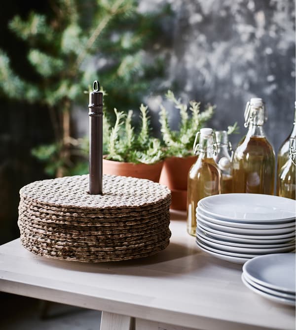 Swedish crisp bread on a paper towel holder next to a stack of plates.