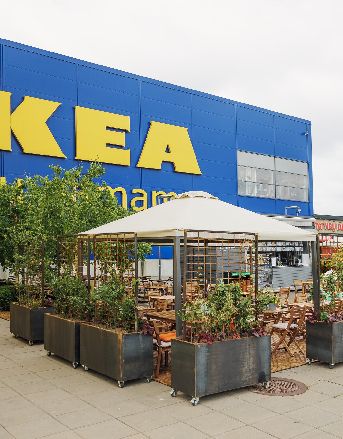 Swedish Deli, featuring wooden seating, planters with greenery and a shaded pergola in front of the IKEA store.