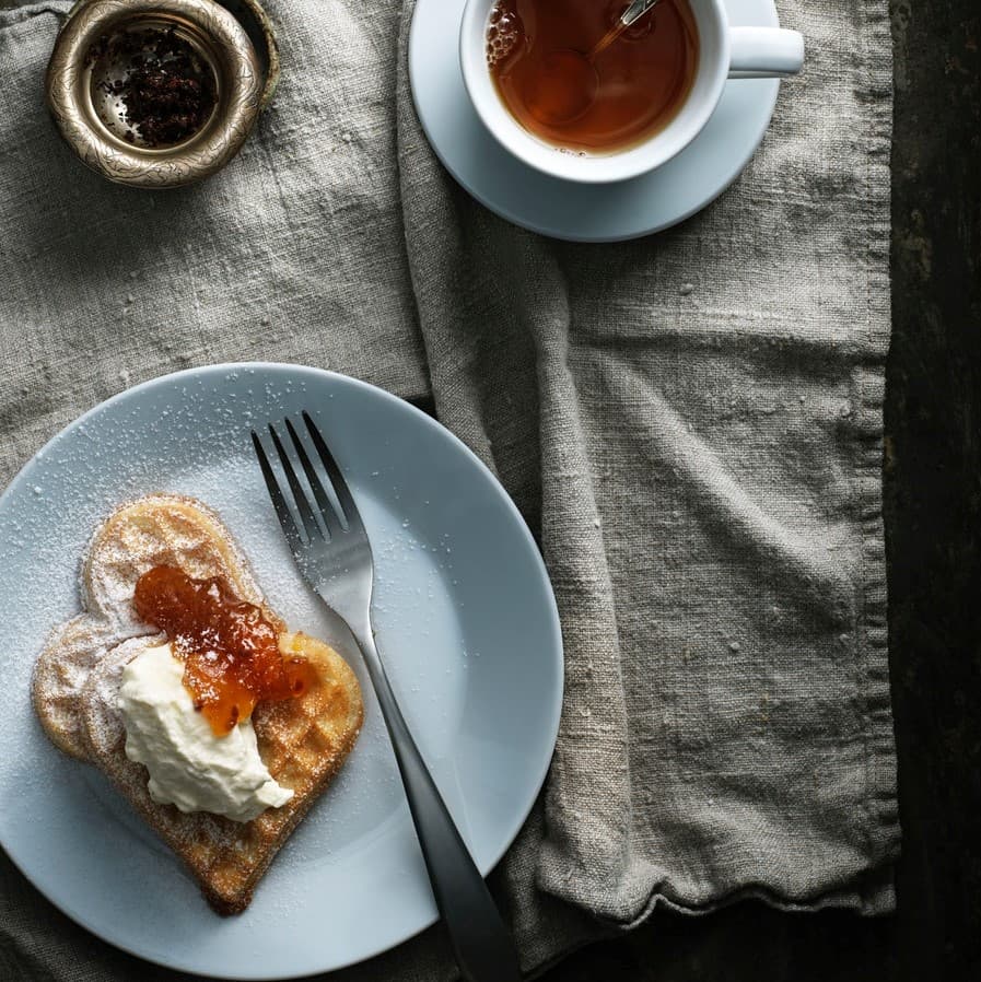 Sweet waffles with cloudberry jam and whipped sour cream
