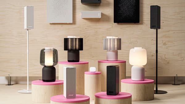 SYMFONISK lampa med wifi-högtalare tillsammans med olika prydnadssaker och tidskrifter.