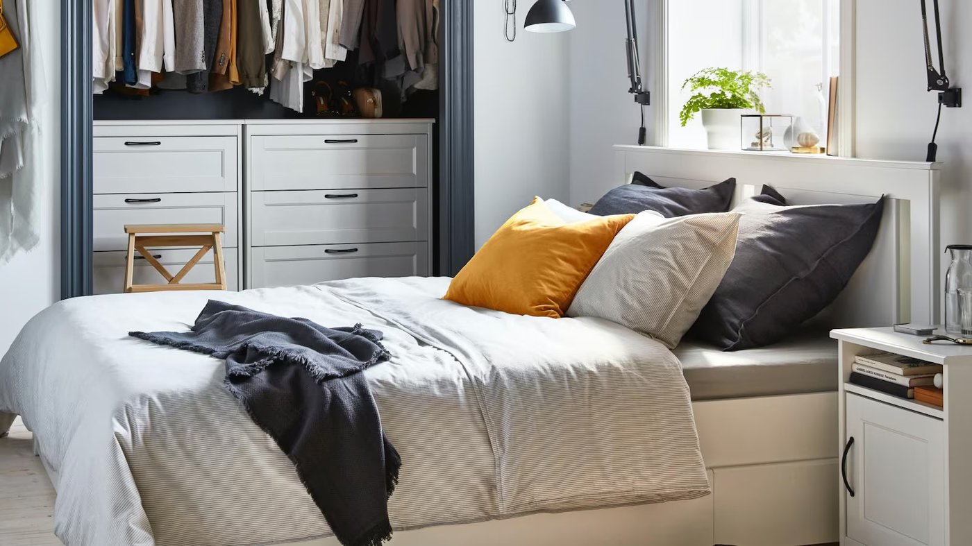 sypialnia z białym łóżkiem i szafą