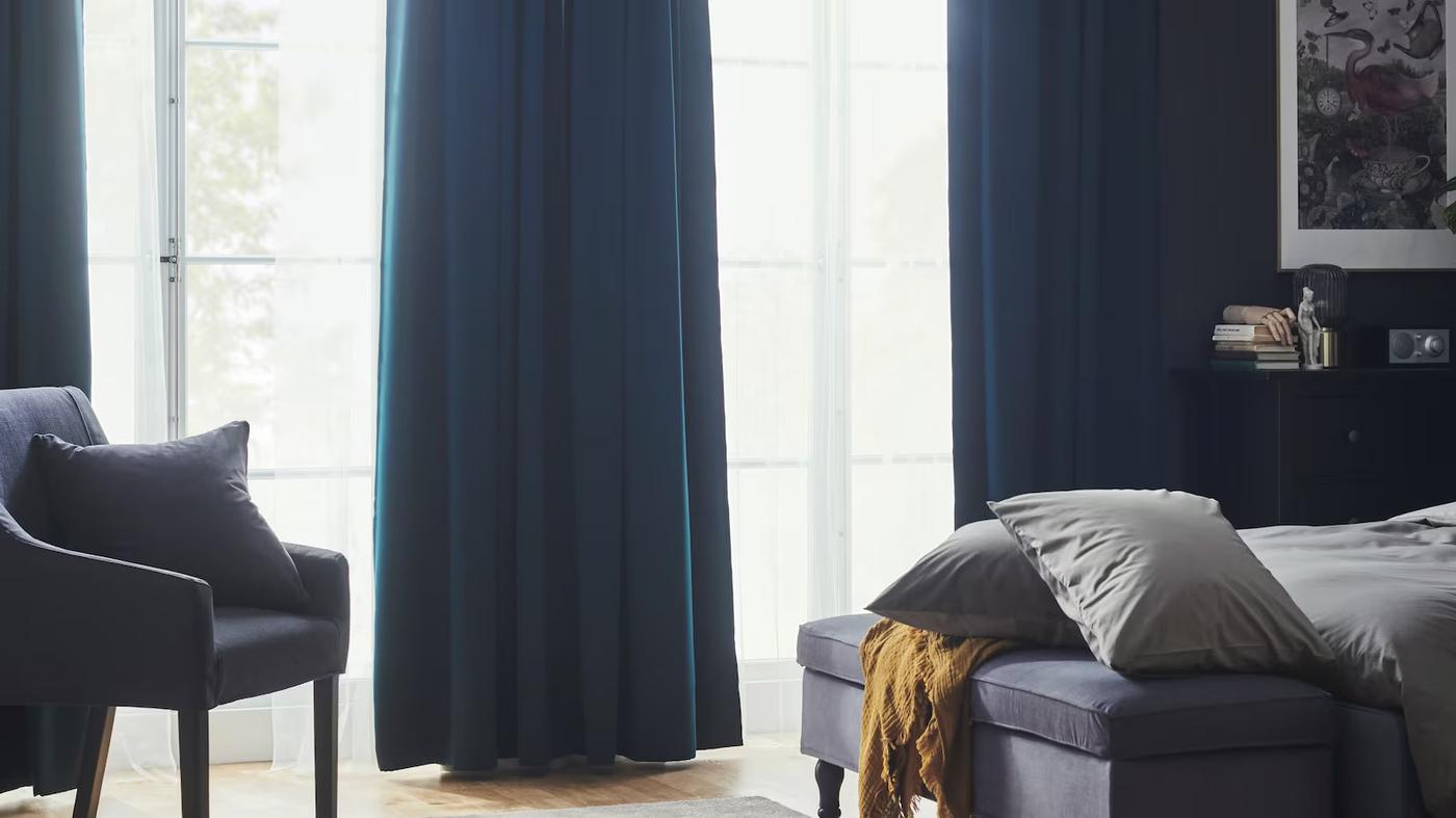 sypialnia z długimi granatowymi zasłonami w oknie