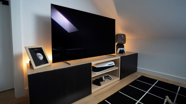 Szafka pod TV BESTÅ z fronatmi LAPPVIKEN i stojącym na niej telewizorem.