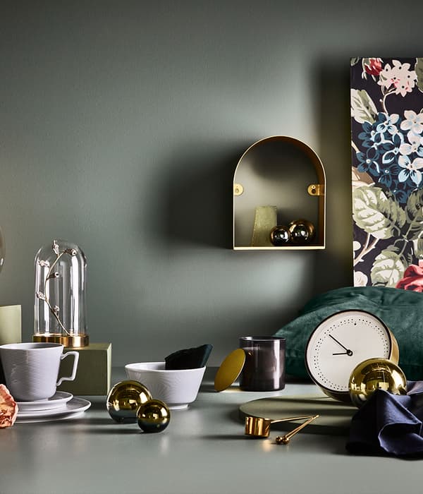 table avec différents bibelots de décorations avec une étagère accroché au mur et des décorations dedans