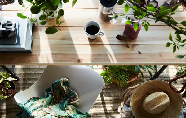 Table de petit déjeuner décorée de verdure, naturelle et artificielle, comme la plante en pot FEJKA.