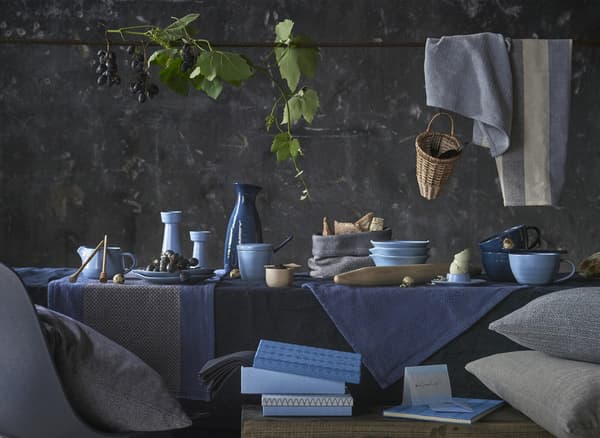 Table décorée d’objets en céramique et de textiles dans des tons de bleu.