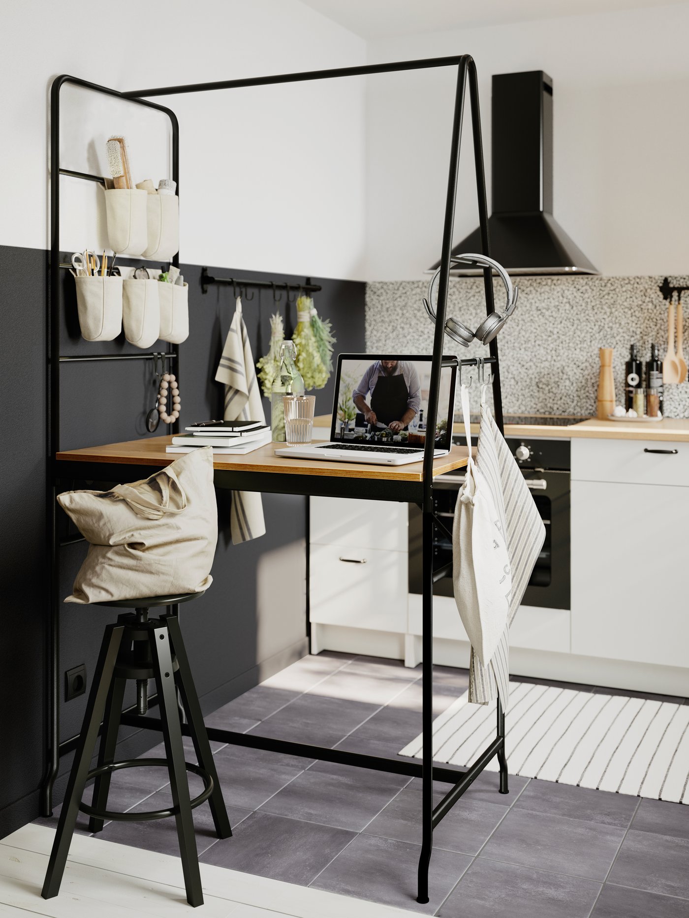 Table HÅVERUD noire avec sacs accrochés à l’échelle de rangement d’un côté, torchon et casque audio de l’autre.