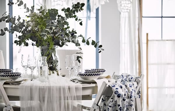 Table toute romantique drapée de tulle et garnie de fleurs sauvages et de branches d’eucalyptus.