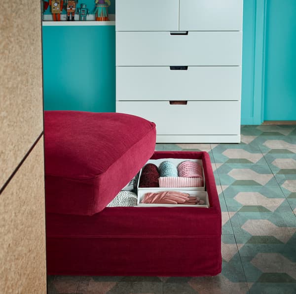 Taburetul GRÖNLID cu depozitare, roșu închis, de la IKEA, are un compartiment în interior, la care ajungi deschizând partea capitonată de sus a acestuia.  Are o căptușeală albă, cu sistem de ventilație în interior. 