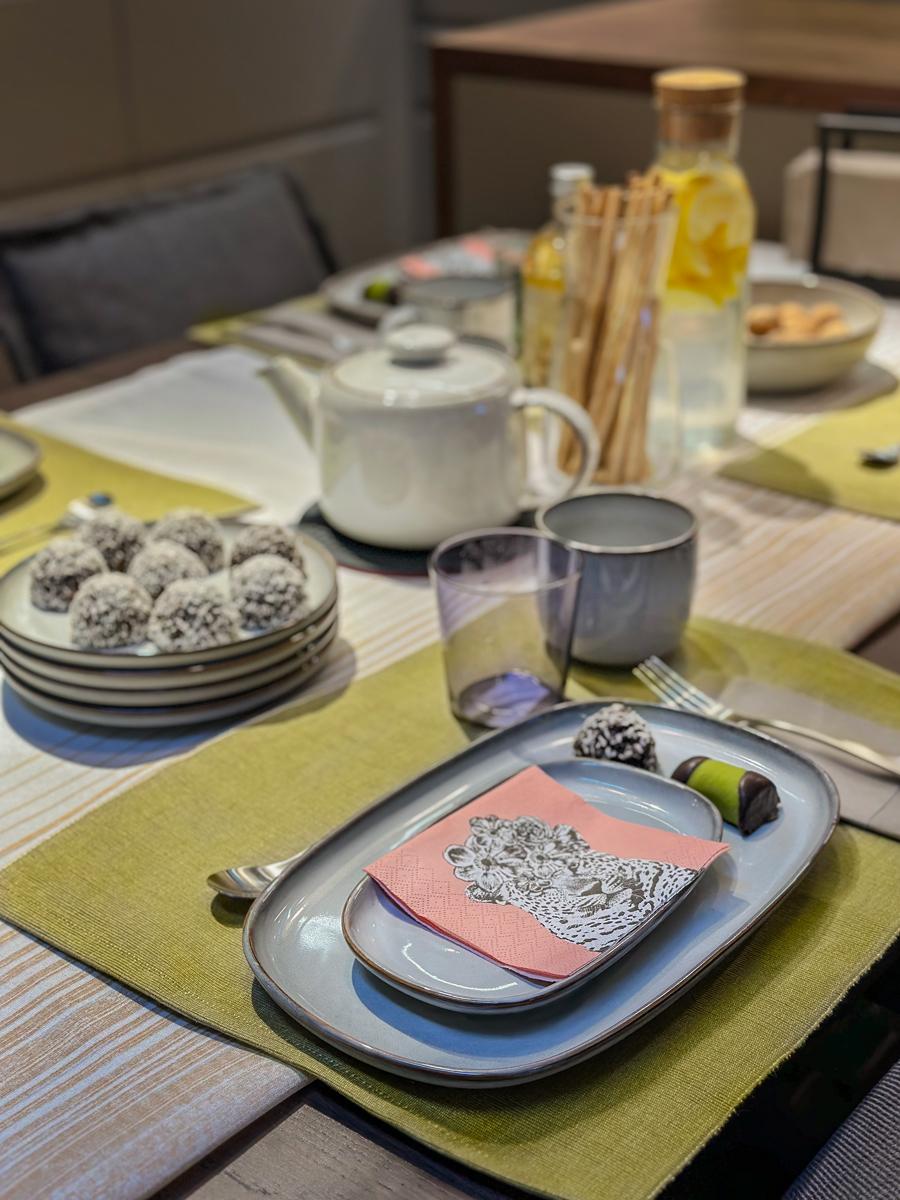 Talerze z kamioki zaprezentowane na zieloej podkładce. Serweta z motywem głowy tygrysa.