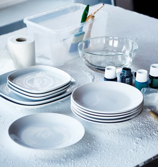 Talíře IKEA FÄRGRIK jsou položené na stole a připravené na pomalování.